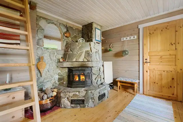 Lun stue med stor og sjarmerende natursteinpeis som skaper et lunt samlingspunkt i stua og gir ekte hyttefølelse