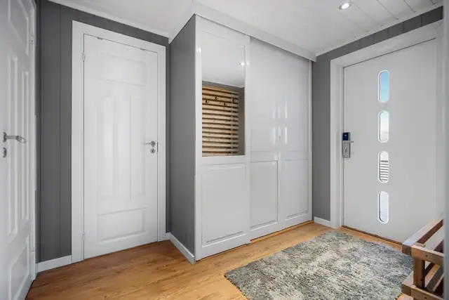 Romslig entré med skyvedørsgarderobe som gir rikelig plass til yttertøy.