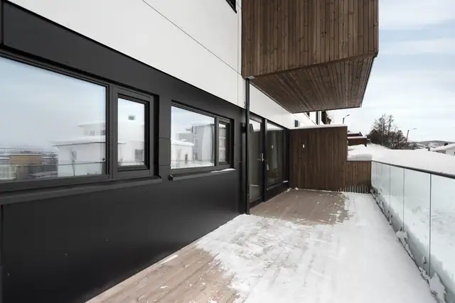 Verandaen har glassrekkverk som gir et moderne uttrykk og godt lysinnslipp, samt en praktisk skillevegg som skjermer mot innsyn og gir le.
