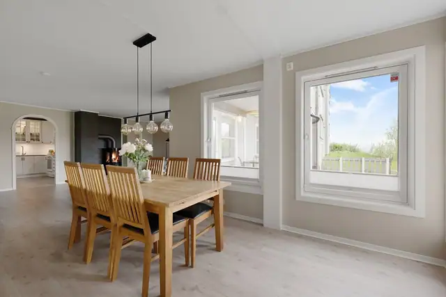 God plass til et stort spisebord, med flott utsikt som skaper en hyggelig ramme rundt måltidene.