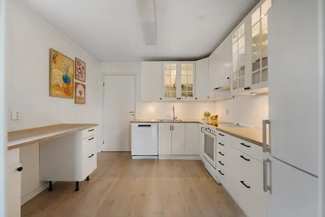 Innbydende kjøkken med elegante, profilerte fronter som tilfører rommet karakter og sjarm. Praktisk laminatbenkeplate med gode arbeidsflater og enkel vedlikehold.