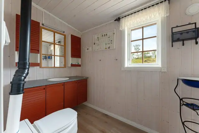 Praktisk WC-rom med baderomsinnredning, nedfelt servant og biotoalett.