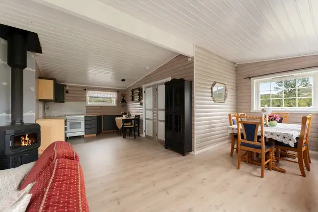 Vedfyring som kan nytes fra både sofakroken og spisestuen, og som skaper en lun og hyggelig atmosfære.