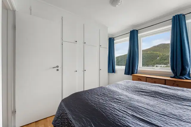 Innbydende soverom med god plass for soveromsmøbler, rommet inneholder plassbygde skap som gir rikelig med praktisk oppbevaring.