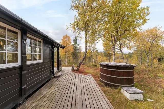 Romslig veranda med god plass til møblering, perfekt for hyggelige måltider og avslappende stunder utendørs.