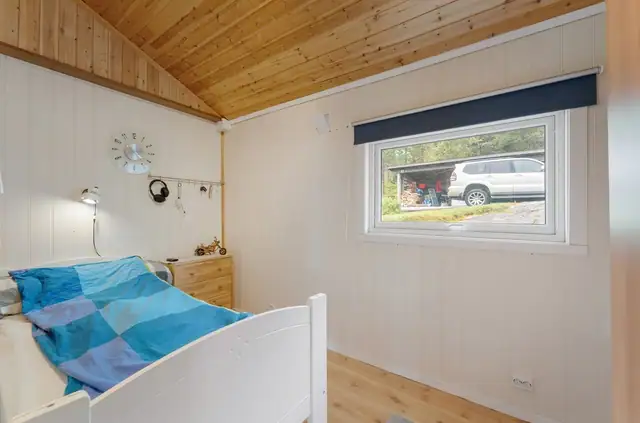 Soverom 1-Romslig soverom med god plass til seng og praktiske oppbevaringsmøbler.