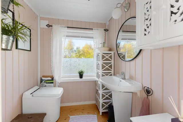 Toalettrom med forbrenningstoalett og servant.