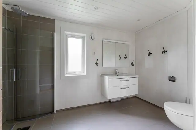 Badet er renovert i 2019 og fremstår lyst og innbydende. Veggene er utført med våtromsplater og fliser i dusjsonen, mens himlingen har smartpanel og innfelte spotter.