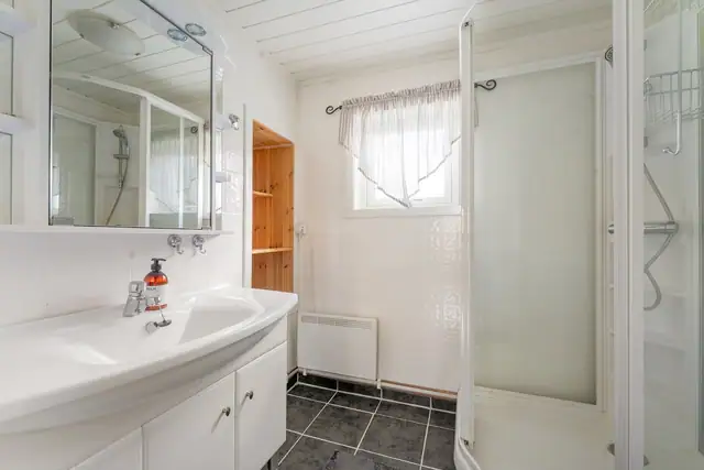 Badet har vegger med våtromsplater og panel i himlingen. Gulvet er flislagt og har panelovn.