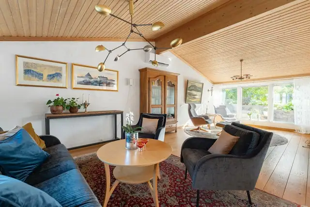 Velkommen inn! Imponerende, romslig stue med ekstra takhøyde og store vindusflater som gir en fantastisk følelse av lys og luft. Her er det god plass til å skape flere hyggelige møbleringssoner.