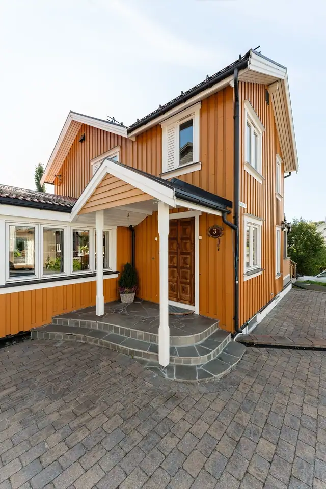 Innbydende og overbygget inngangsparti med skiferlagt trapp, som gir en hyggelig og solid adkomst til boligen.