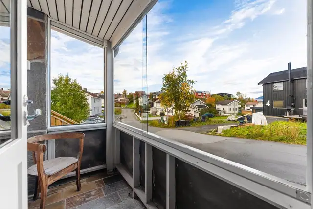 Innglasset balkong som gir en lun og skjermet uteplass, perfekt for å nyte dagene fra tidlig vår til sen høst.