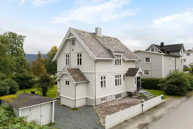 Eiendommen strekker seg over fire etasjer og ligger på en stor og flott opparbeidet tomt med romslig hage.