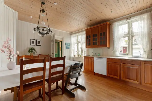 Romslig kjøkken med god plass til både oppbevaring og arbeidsflater, samt et stort spisebord for hyggelige måltider og sosialt samvær.