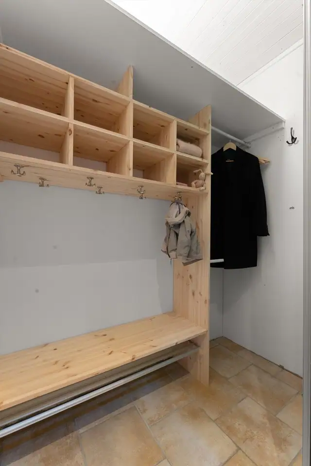 Flislagt entré med plassbygde hyller og oppheng, samt god plass til praktisk oppbevaring.