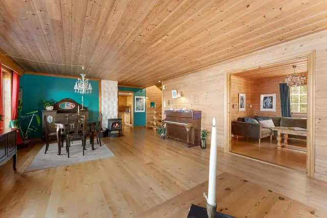 Stuen har god plass til møblering i flere soner, samt vedovn som skaper en lun og hyggelig atmosfære.