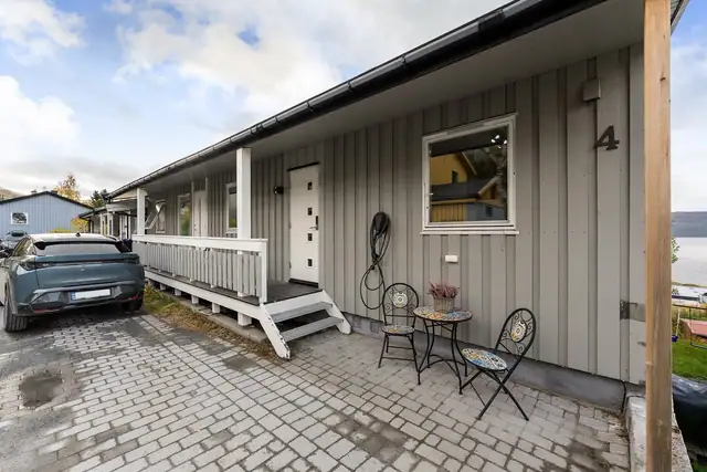 Innbydende inngangsparti med overbygd adkomst. Oppkjørselen og området rundt trappen er pent belagt med belegningsstein.