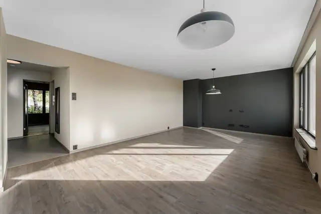 Stor og åpen stue malt i moderne farger, med en lun og innbydende atmosfære.